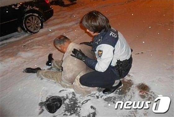 본문 이미지 - 이다혜 순경 작, '교통사고 예방 순찰 중 저체온증으로 손발이 굳어진 주민을 응급처치하는 모습. ⓒ News1