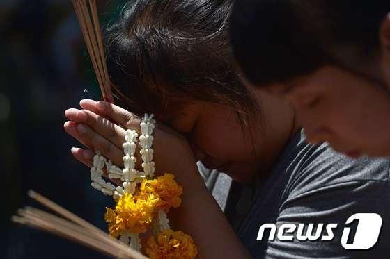 본문 이미지 - 19일(현지시간) 다시 문을 연 태국 방콕 에라완 사원을 찾은 여성들이 테러 희생자들을 위해 기도하고 있다. ⓒ AFP=뉴스1