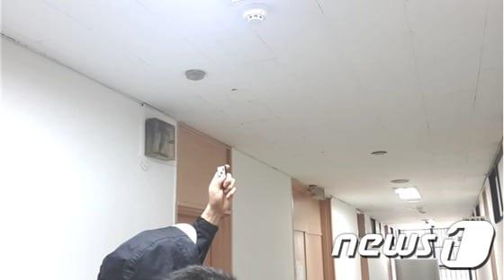 본문 이미지 - 피의자  김모(49)씨가 화재경보기형 몰래카메라를 설치한 뒤 작동해보고 있다. (서울 송파경찰서 제공) 2015.8.23/뉴스1 ⓒ News1