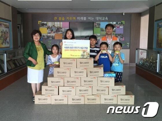 본문 이미지 - 이금숙 대덕초(완쪽)교장과 아이들이 월드비젼에 사랑의 동전 모으기 성금 전달하고 있다.ⓒ News1