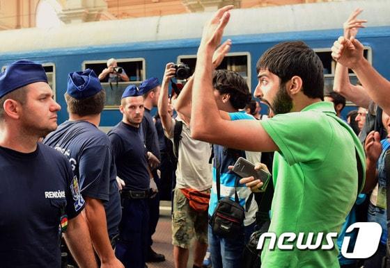 본문 이미지 - 헝가리가 더블린조약 위반 논란에 휩싸이자 부다페스트 역사 열차운행을 중단하고 폐쇄했다 이에 역사에서 쫓겨난 난민들이 경찰을 향해 항의하고 있다. ⓒ AFP=뉴스1
