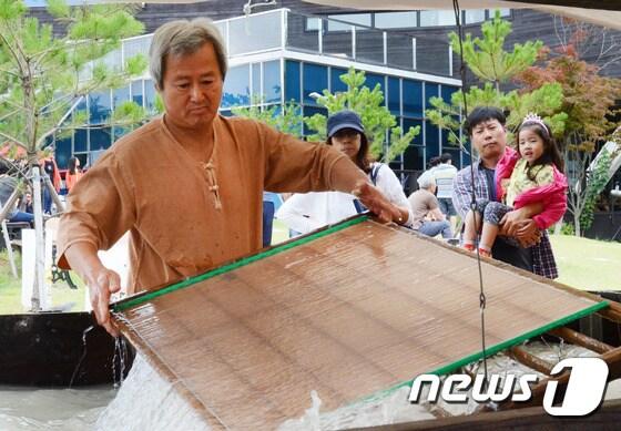 본문 이미지 - 원주한지의 장인 장응열 원주한지장이원주한지문화제에서 한지뜨기 시연을 하고 있다/뉴스1 DB ⓒ News1