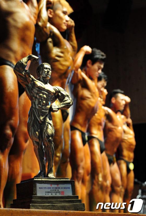 본문 이미지 - 13일 오후 전북 전주시 덕진구청 강당에서 열린 '국민생활체육 보디빌딩 대회'에서 보디빌더들이 운동으로 다져진 근육을 뽐내고 있다.2015.9.13/뉴스1 ⓒ News1 김대웅 기자