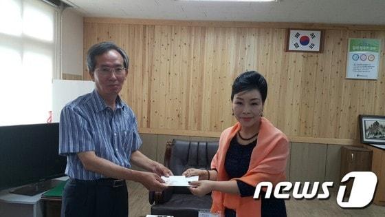 본문 이미지 - 단양 장다리식당 이옥자 대표(사진 오른쪽)가  단양고 육상부에 후원금을 전달하고 있다.ⓒ News1