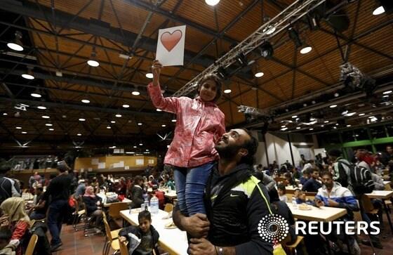 본문 이미지 - 시리아 난민 아빠가 독일 도르트문트 기차역에 도착한 뒤 안도하는 표정으로 딸을 안고 있는 모습. ⓒ News1 우동명 기자