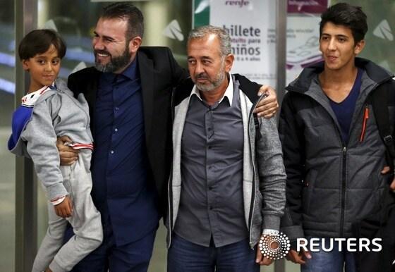 본문 이미지 - 카메라 여기자 발에 걸려 넘어졌던 시리아 축구감독 오사마 압둘 무센(오른쪽에서 두번째)이 그의 아들인 자이드(왼쪽)와 모하메드(오른쪽)와 함께 17일(현지시간) 마드리드에 도착했다. ⓒ 로이터=뉴스1