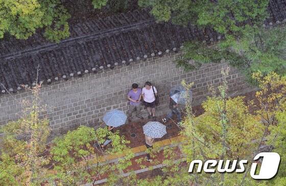 본문 이미지 - 가을 소나기가 내리고는 서울 중구 정동 덕수궁 돌담 아래에서  시민들이 비를 피하고 있다. ⓒ News1