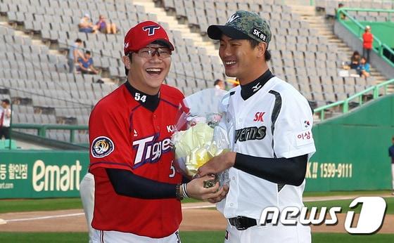 본문 이미지 - 21일 오후 인천 SK행복드림구장에서 열리는 '2015 타이어뱅크 KBO 리그' SK 와이번스와 KIA 타이거즈의 경기 시작전 양현종이 '김광현 1,000탈삼진 달성 시상식'에서 김광현에게 꽃다발을 건내고 있다. (SK 와이번스 제공) 2015.9.21/뉴스1 ⓒ News1 송원영 기자