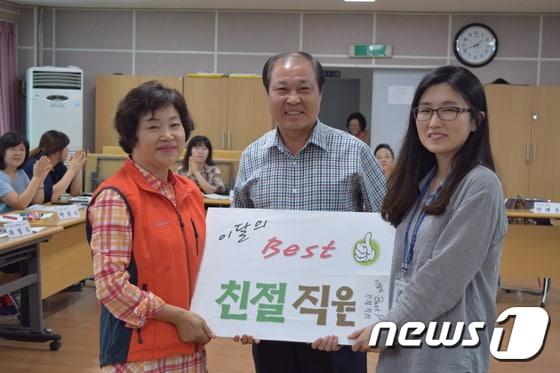 본문 이미지 - 전주시 완산구 서서학동 주민센터에 근무하는 조아라(오른쪽) 주무관이 이달의 친절직원으로 선정됐다.  최은자(왼쪽) 통장협의회 회장과 김진호 (가운데) 동장이 조아라 주무관과 기념촬영을 하고 있다. (서서학동제공)2015.9.30/뉴스1ⓒ News1