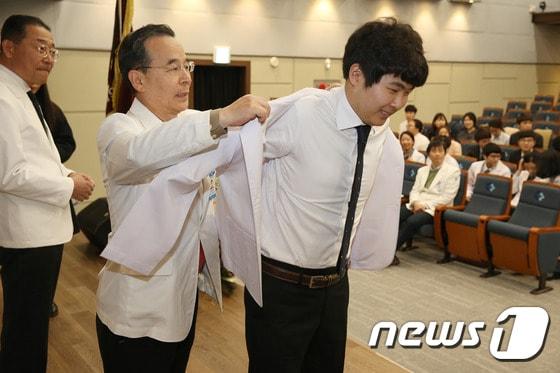 본문 이미지 - 22일 동아대학교 의과대학은 동아대병원 대강당에서 화이트 코트 세레모니(White coat Ceremony)를 개최했다.(동아대 제공) ⓒ News1