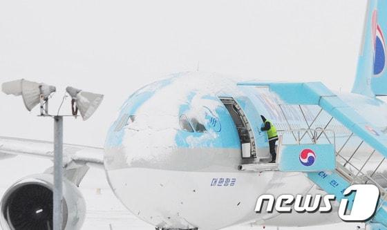 본문 이미지 - 2016년 1월24일  제주국제공항 활주로에 눈이 쌓여 운항을 포기한 항공기가 멈춰서 있다.2016.1.24/뉴스1 ⓒ News1 이석형 기자