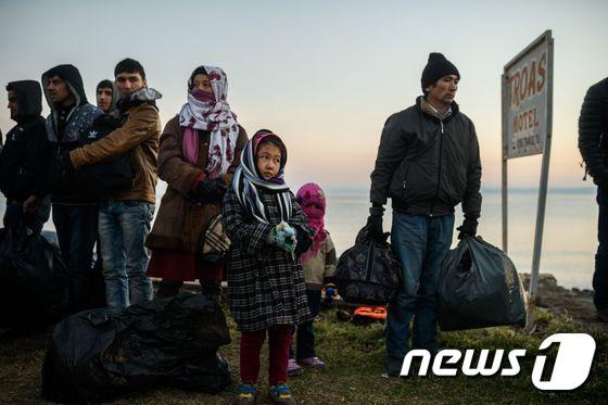 본문 이미지 - 터키와 아프가니스칸의 이주자들과 난민들이 27일(현지시간) 터키 차나칼레에 있는 쿠추쿠유 지구에서 터키 경찰에 잡힌 뒤 대기하고 있다. ⓒ AFP=뉴스1