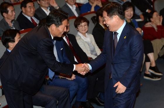 본문 이미지 - 2016년 10월 15일 정청래 의원의 '정청래의 국회의원 사용법' 출판기념회에 참석한 당시 이재명 성남시장이 정 의원과 악수를 나누고 있다. ⓒ News1 