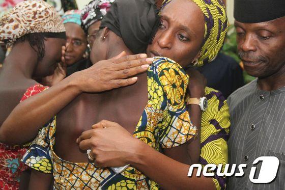 본문 이미지 - 예미 오신바조 나이지리아 부통령(오른쪽)이 13일(현지시간) 자신의 아내 도팔로(중앙)가 석방된 21명의 아이들을 안아주는 모습을 지켜보고 있다.ⓒ AFP=뉴스1