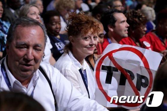 본문 이미지 - 미국 전당대회가 시작된 첫날인 지난 해7월25일 미국 배우 수잔 서랜든이 필라델피아 웰스파고 센터에서 TPP(환태평양경제동반자협정)라 쓰인 팻말을 들고 있다. ⓒ News1