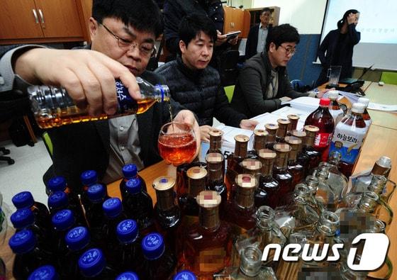 본문 이미지 - 2일 전북 전주시 전북경찰청 브리핑룸에서 전주덕진경찰서소속 형사가 연 40억 상당 가짜 양주 제조·판매 일당 검거 브리핑에 앞서 생수병에 담긴 가짜양주를 잔에 따르고 있다.2016.11.2/뉴스1 ⓒ News1 문요한 기자