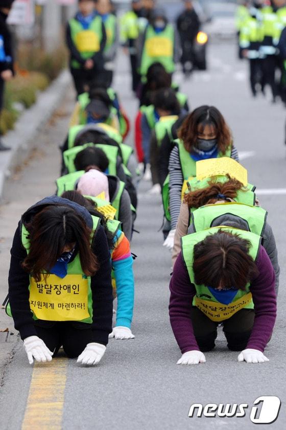 본문 이미지 - 발달장애인 및 가족 50여명이 지난 2016년 11월21일 오전 광주 서구 5·18기념문화센터 인근 도로에서 '발달장애인 지원체계 마련'을 촉구하며 3보1배를 진행하고 있다. 2016.11.21 /뉴스1 ⓒ News1 황희규 기자