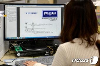 본문 이미지 - 23일 서울 세종로 정부서울청사에서 한 공무원이 '박근혜 정부의 최순실 등 민간인에 의한 국정농단 의혹 사건 규명을 위한 특별검사 임명법(특검법)' 공포안이 게재된 전자 관보를 열람하고 있다. 2016.11.23/뉴스1 ⓒ News1 안은나 기자