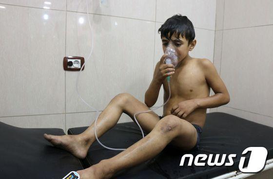 본문 이미지 - 한 소년이 9월 시리아 알레포에서 염소가스가 든 통폭탄을 맞고 호흡 곤란을 호소하고 있다. ⓒ AFP=뉴스1