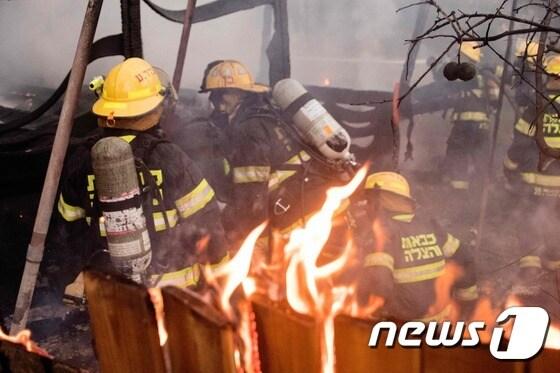 본문 이미지 - 이스라엘 소방관이 25일(현지시간) 항구도시 하이파에서 산불을 진화하고 있다. ⓒ AFP=뉴스1