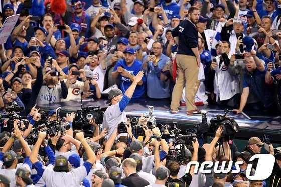 본문 이미지 - 시카고 컵스 선수와 팬들이 3일(한국시간) 오하이오 주 클리블랜드 프로그레시브 필드에서 열린 2016 메이저리그 월드시리즈 7차전에서 클리블랜드 인디언스를 꺾은 뒤 기뻐하고 있다. ⓒ AFP=Nesw1