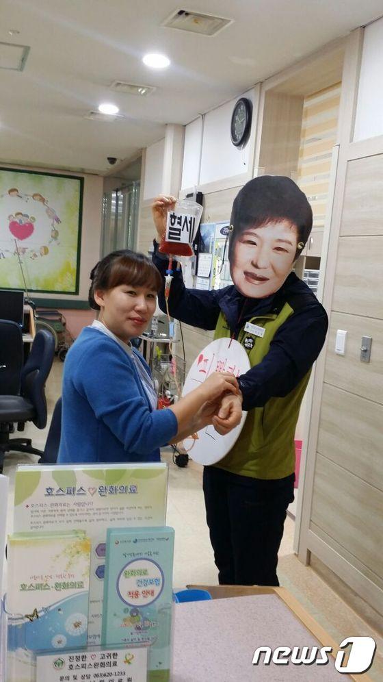 본문 이미지 - 남원의료원지부 노동자가 30일 국민의 피를 빨아먹는 박근혜 대통령이라는 퍼포먼스를 펼치고 있다.(남원의료원지부 제공)2016.11.30/ⓒ News1