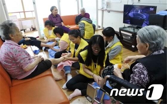 본문 이미지 - 어르신들에게 발마사지를 해드리고 있는 학생들.(용인시 청소년미래재단 제공)ⓒ News1