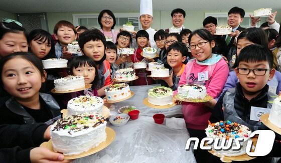 본문 이미지 - 12일 전북 전주시 전주콩나물영농조합에서 열린 '어린이와 함께하는 Farm Festival'에 함께한 김승수 전주시장, 김명지 전주시의장과 장동초등학교 학생들이 밀순과 초콜렛 등으로 토핑을 올려 만든 쌀케이크를 선보이고 있다.2016.12.12/뉴스1 ⓒ News1 문요한 기자