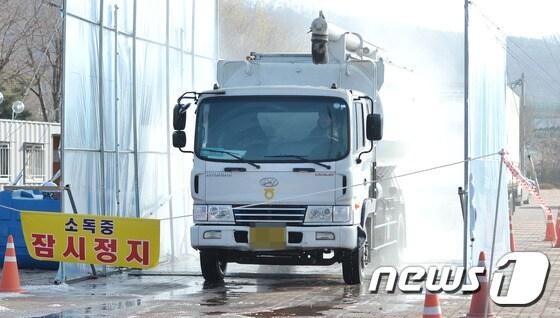 본문 이미지 - 천안지역 산란계와 육용오리 등 가금류 농장 3곳에서 AI가 발생한 15일 오후 천안 삼거리 공원 인근에 설치된 거점 소독시설에서 차량을 소독 하고 있다. 2016.12.15/뉴스1 ⓒ News1 주기철 기자