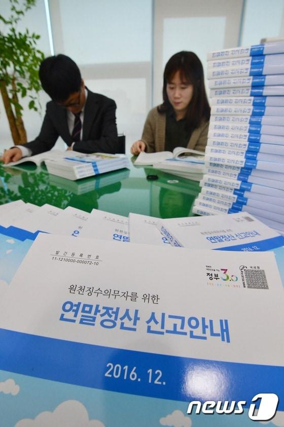 본문 이미지 - 20일 오후 서울 종로세무서에서 직원들이 2016년 연말정산 안내 책자를 살펴보고 있다.2016.12.20/뉴스1 ⓒ News1 민경석 기자