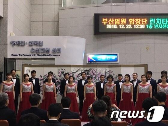 본문 이미지 - 부산법원은 22일 부산법원종합청사 1층 로비에서 점심시간을 활용해 법원을 찾은 민원인과 법원 직원들의 심금을 울리는 ‘런치타임 콘서트’를 열었다. 이날 박영재 부산고법 부장판사, 김찬돈 부산고법 부장판사, 임상민 부산지법 판사 및 법원 직원들로 구성된 부산법원 합창단은 수개월 준비해 온 실력을 한껏 뽐냈다. 2016.12.22ⓒ News1 김항주 기자