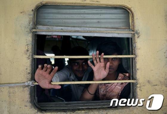 본문 이미지 - 25일 (현지시간) 파키스탄 카라치의 감옥에서 풀려난 인도 어부들이 열차 창문으로 밖을 내다보고 있다. 파키스탄은 핵 무장 경쟁국 인도와 관계개선의 표시로 영해침범죄로 수감해온 인도 어부 220명을 석방했다. ⓒ AFP=뉴스1 ⓒ News1 우동명 기자
