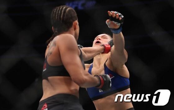 본문 이미지 - 1년1개월여만에 복귀전에 나선 론다 로우지(미국·오른쪽)가 31일(한국시간) 미국 라스베이거스 T-모바일 아레나에서 열린 UFC 207 메인 경기에서 아만다 누네스(브라질)에 48초만에 KO패 당했다. ⓒ AFP=News1