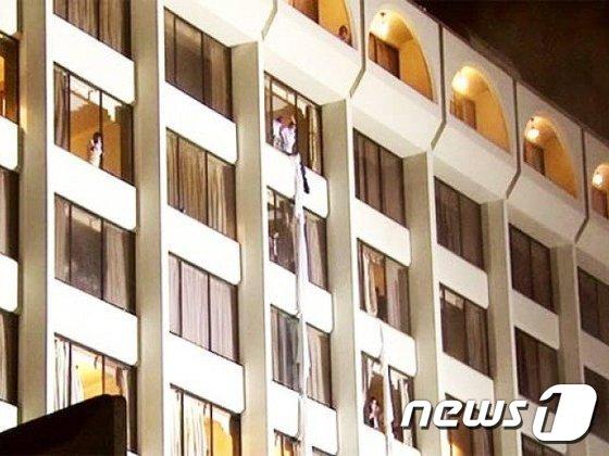 본문 이미지 - 5일(현지시간) 오전 파키스탄 항구 도시 카라치의 4성급 호텔에서 대형 화재가 발생해 승객들이 이불과 옷가지를 연결해 창문 밖으로 탈출하고 있다. 이 사고로 최소 11명이 숨지고 70명이 다쳤다. (현지 방송 갈무리) ⓒ News1