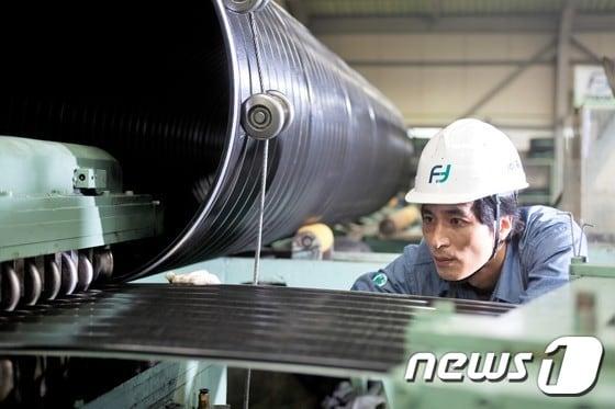 본문 이미지 - ㈜픽슨의 한 직원이 진지한 표정으로 파형 강관 생산공정을 지켜보고 있다.(픽슨 제공)2016.12.6/뉴스1 ⓒ News1 서순규 기자
