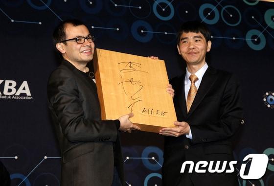 본문 이미지 - 이세돌 9단이 15일 오후 인공지능 알파고와의 ‘구글 딥마인드 챌린지 매치’ 5번기 제5국을 마친 뒤 서울 광화문 포시즌스호텔에서 데미스 하사비스 구글 딥마인드 대표에게 바둑판에 사인을 해서 선물을 하고 있다. ⓒ News1 송원영 기자