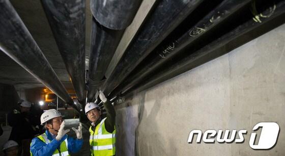 본문 이미지 - 박원순 서울시장이 정릉천고가 교량 상부구조물 내부에서 시설관리공단 관계자와 함께 일부 교체를 한 대형케이블을 살펴보고 있다. /뉴스1 ⓒ News1 
