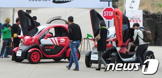 본문 이미지 - 제3회 국제전기자동차엑스포 개막 3일째인 20일 르노삼성자동차 체험부스에서 관람객들이 미니 전기자동차를 구경하고 있다.2016.3.20/뉴스1 ⓒ News1 이석형 기자