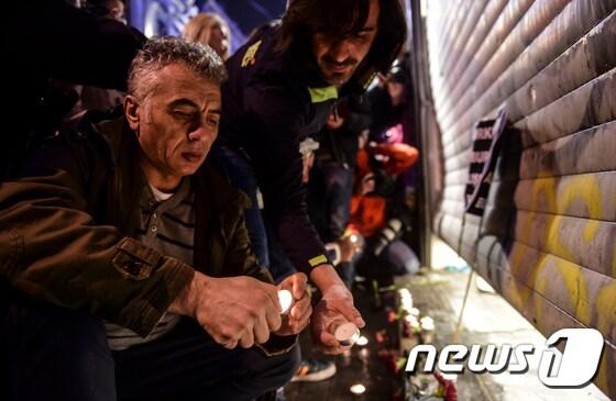 본문 이미지 - 19일(현지시간) 터키 이스탄불 최대 번화가 이스티크랄 거리에서 자살폭탄 테러가 일어나 4명이 숨지고 39명이 다쳤다. 시민들이 이스티크랄 거리에서 희생자를 기리는 촛불을 켜고 있다. ⓒ AFP=뉴스1