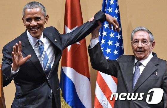 본문 이미지 - 2016년 3월21일(현지시간) 당시 라울 카스트로 쿠바 국가평의회 의장이 아바나의 혁명궁전에서 열린 정상회담 중 버락 오바마 미국 대통령의 팔을 들어올리고 있다. 오바마 대통령과 카스트로 의장은 오랜기간 적대적 관계였던 양국이 '새 시대'를 열기위해 공동노력하기로 했다.ⓒ AFP=뉴스1 ⓒ News1 우동명 기자