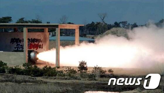 본문 이미지 -   북한군이 24일 실시한 고출력 고체 로켓 발동기(엔진) 지상 분출 및 계단분리시험(단분리 실험) 동안  화염을 내뿜는 실험장 벽면에는 '미제와 박근혜 패당에게 무자비한 불벼락을!'이란 문구가 적혀 있다. (노동신문) 2016.3.24/뉴스1 ⓒ News1 조현아 인턴기자