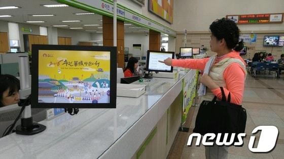본문 이미지 - 경기 수원시차량등록사업소에 설치된 ‘자동차 등록번호 선택기’를 이용하고 있는 시민. ⓒ News1