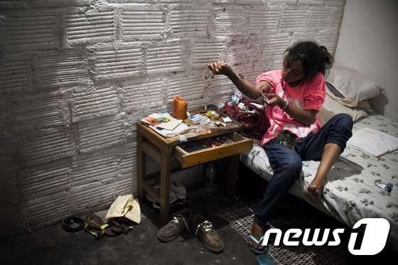본문 이미지 - 지난 2월6일 (현지시간) 콜롬비아 칼리에서 15년동안 헤로인에 중독된 30세 남성이 스스로 헤로인을 주사하고 있다. ⓒ AFP=뉴스1 ⓒ News1 우동명 기자