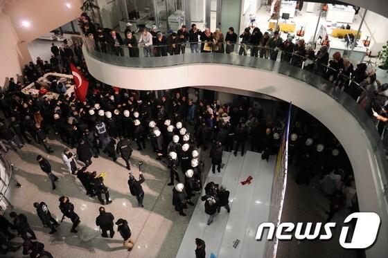 본문 이미지 - 레제프 타이이프 에르도안 터키 대통령에 비판적 논조를 유지해 온 터키 최대 일간지 자만(Zaman)이 법정관리 명령을 받았다. 이에 항의하는 시위대가 4일(현지시간) 자만 이스탄불 본사를 장악한 가운데 경찰과 대치하고 있다. ⓒ AFP=뉴스1