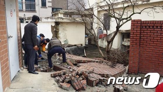 본문 이미지 - 9일 전남 순천경찰이 우체국 주차장의 담장 붕괴 현장을 살펴보고 있다.2016.3.9/뉴스1 ⓒ News1 지정운 기자