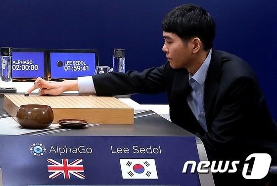 본문 이미지 - 이세돌 9단이 9일 오후 서울 종로구 포시즌스 호텔에서 열린 구글 인공지능(AI) 알파고의 첫 대결에서 첫 수를 두고 있다. 이세돌은 이날 알파고와의 1국에서 불계패했다.(구글 제공) 2015.3.9/뉴스1