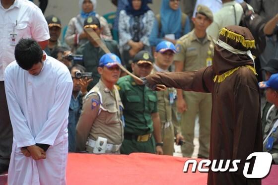 본문 이미지 - 샤리아(이슬람율법) 경찰이 반다 아체에서 샤리아를 위반한 남성을 매질하고 있다. 사진은 지난 3월 1일 촬영된 것이다. ⓒ AFP=뉴스1