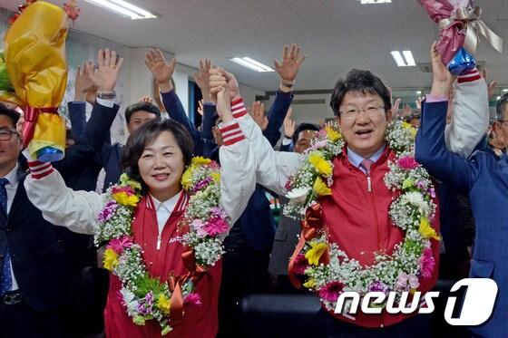본문 이미지 - 제20대 총선 강릉 선거구에 출마한 권성동 새누리당 후보가 13일 당선이 확실시되자 꽃목걸이를 걸고 부인 김진씨와 손을 맞장아 들며 기뻐하고 있다. 2016.4.13/뉴스1 ⓒ News1 서근영 기자