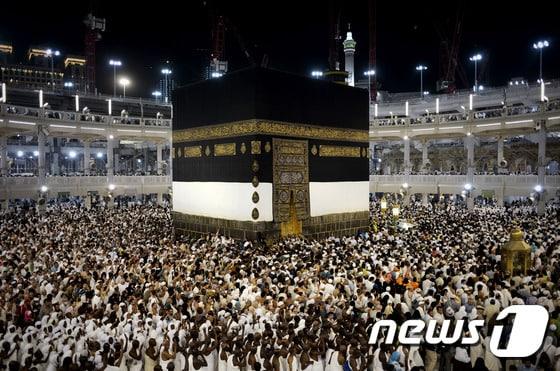 본문 이미지 - 사우디아라비아 메카에 위치한 그랜드모스크 사원의 카바신전 주변을 도는 이슬람 교도들. ⓒ AFP=뉴스1