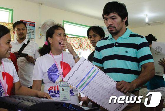 본문 이미지 - 필리핀 복싱 영웅 매니 파퀴아오(37)가 9일 민다나오섬 사랑가니주(州) 키암바에 있는 한 투표소에서 투표하고 있다. ⓒ AFP=뉴스1